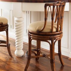 two wooden chairs sitting in front of a counter top with an oven on it's side