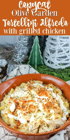 a casserole dish with cheese and sauce in an orange bowl on a table