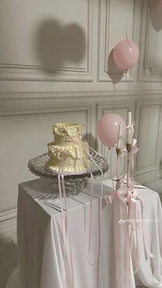 a table topped with a cake and balloons