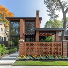 a brick house with landscaping and trees in the front yard on a nice fall day