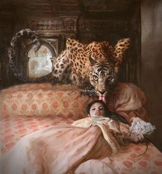 a woman laying on top of a bed next to a large leopard in a room