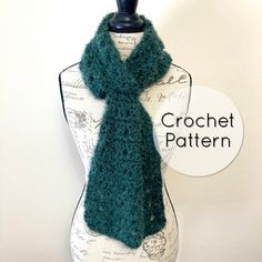 a green knitted scarf sitting on top of a mannequin