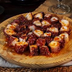 an octopus dish is served on a wooden platter