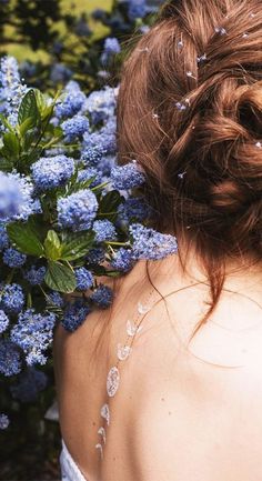 a woman with red hair and blue flowers in her back