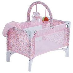 a pink baby crib with a teddy bear on top