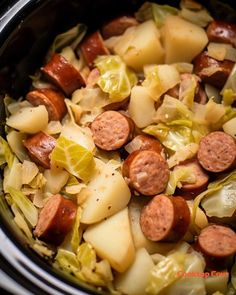 a crock pot filled with sausage, cabbage and potatoes