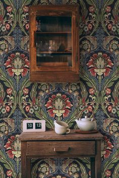 a wooden table with two bowls on it in front of a wallpapered room