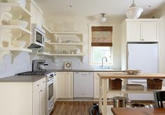 a kitchen with white cabinets and wooden floors