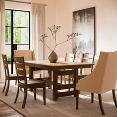 a dining room table with chairs and a vase on it