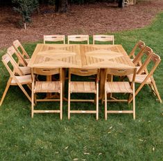 a wooden table and chairs sitting in the grass