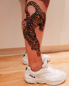 a person with a tiger tattoo on their leg