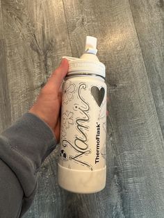 a hand holding a white and black shaker bottle with the word love written on it