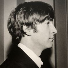 a black and white photo of a man in a suit looking off into the distance