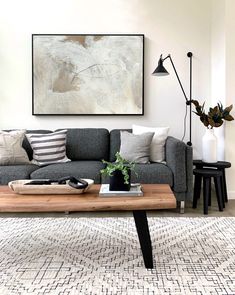 a living room with a couch, coffee table and pictures on the wall above it