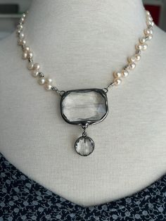 White Freshwater Pearls separated by silver spacers. Crystal clear glass pendant with a drop bead. The pearls are top drilled so they have a ruffled effect. Toggle clasp for easy on and off.  The total length of the necklace is 18 inches with a 2 inch pendant drop.  Clear crystal is encased in gunmetal like stained glass. Artisan Necklace, Boho Pendant, White Freshwater Pearl, Drop Beads, Pearl Shell, Vintage Pearls, Toggle Clasp, Pendant Set, Glass Pendant