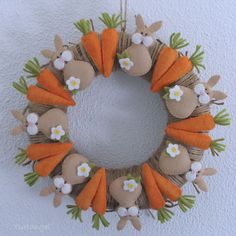 a wreath with carrots and daisies hanging on the wall