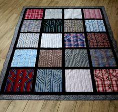 a patchwork quilt is on the floor with many different colors and patterns in it