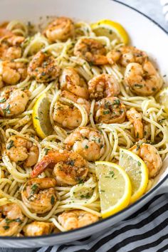 shrimp pasta with lemon and parsley in a white bowl on a striped tablecloth