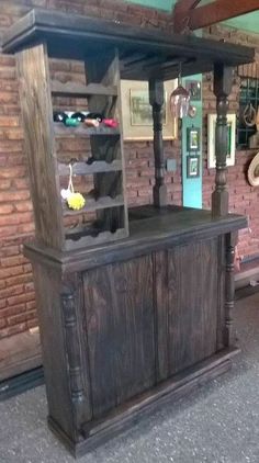 an old fashioned bar in a room with brick walls and flooring, along with other items on display