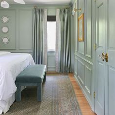 a bedroom with green walls and white bedding