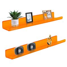 there are two orange shelves with pictures on them and one has a plant in it