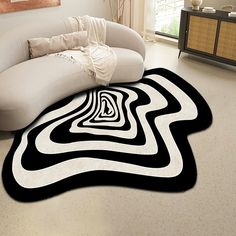 a black and white area rug in the middle of a living room with a couch