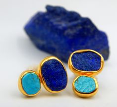 Rough Lapis Lazuli and Turquoise Stud Earrings made out of 18 karat Gold plated Sterling Silver. 100% Handmade Jewellery. LAPIS LAZULI: The sweet sounding, melodic name of this gem is composed of 'Lapis', the Latin word for stone, and 'Azula', which comes from the Arabic and means 'blue'. Historians believe the link between humans and lapis lazuli stretches back more than 6,500 years. The gem was treasured by the ancient civilizations of Mesopotamia, Egypt, China, Greece, and Rome. They valued i Blue Natural Stone Earrings As Gift, Blue Oval Earrings With Natural Stones, Turquoise Lapis Lazuli Jewelry Gift, Turquoise Lapis Lazuli Jewelry For Gift, Oval Stone Earrings Gift, Oval Stone Earrings For Gift, Turquoise Gemstones With Accents For Gifts, Lapis Lazuli Earrings, Peridot Pendant