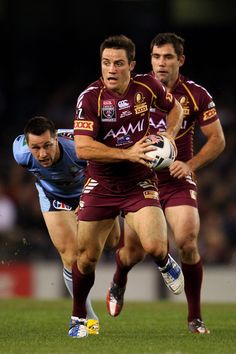 two rugby players are running with the ball