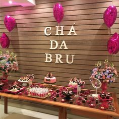 a table topped with lots of cakes and cupcakes next to a sign that says cha da bru