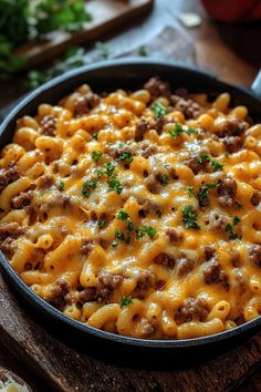 a skillet filled with macaroni and cheese on top of a wooden cutting board