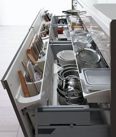 an open drawer with dishes and utensils in the drawers on both sides is shown