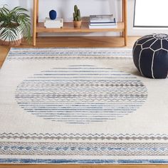 a white rug with blue and grey stripes on it in front of a wooden shelf