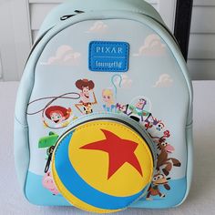 the back side of a blue backpack with cartoon characters on it and a red star