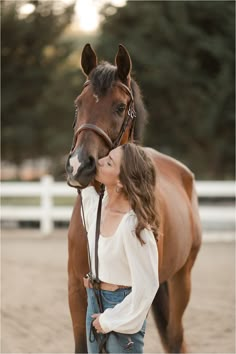 a woman standing next to a brown horse