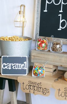 an assortment of candy and candies on display in front of a chalkboard sign