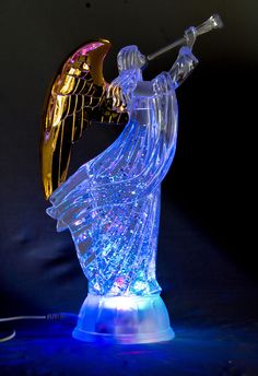 an illuminated angel figurine holding a trumpet