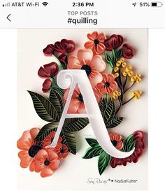 the letter a is made out of paper and has flowers on it's side