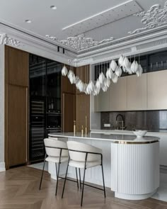 an elegant kitchen with white chairs and marble counter tops, along with wooden flooring