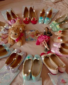 there are many pairs of shoes on the bed with a teddy bear sitting between them