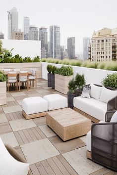 an outdoor living area with couches, tables and plants on the roof top deck