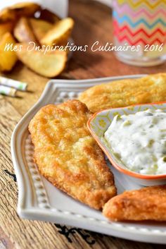 some fried food on a white plate with dipping sauce