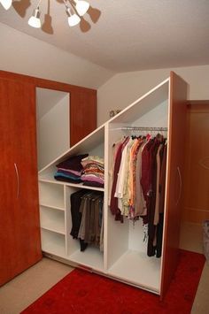 a closet with clothes hanging on it and a red rug in front of the closet