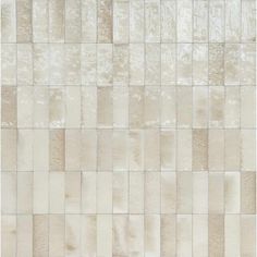 a white and beige tile wall with squares