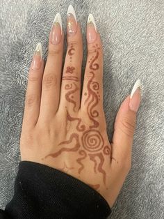 a woman's hand with white and brown designs on it