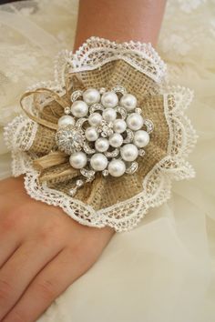 a close up of a person's hand wearing a bracelet with pearls on it