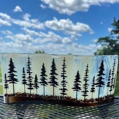 a glass dish with trees painted on it