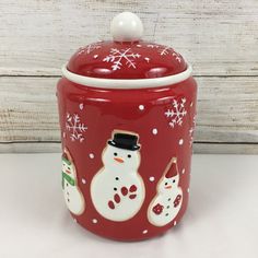 a red cookie jar with snowmen on it