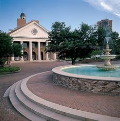 a fountain in front of a building with a clock on it