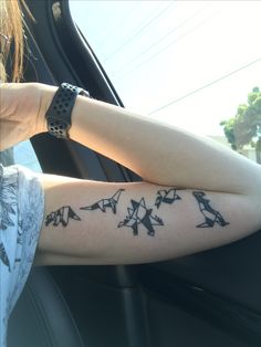 a woman's arm with birds on it in the back seat of a car