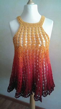 a white mannequin wearing a red and yellow crochet top